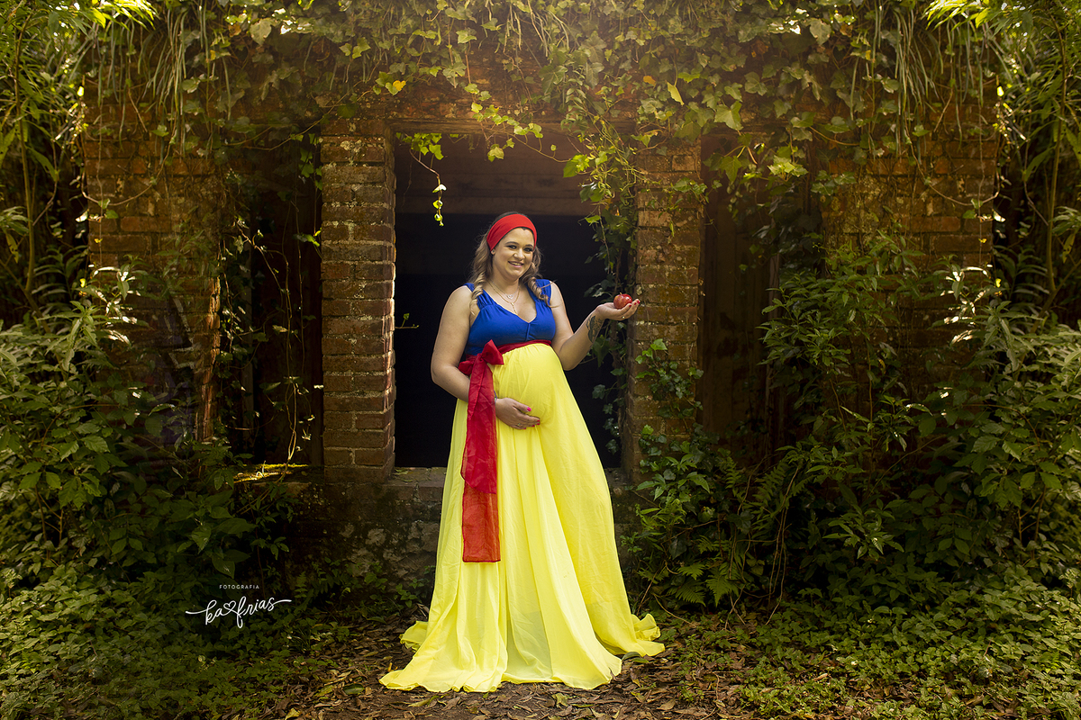 a gestante esta vestida de branca de neve para a sessão