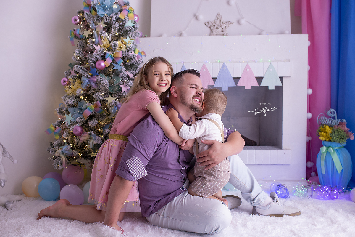 o pai posa com os filhos no ensaio de natal 2021