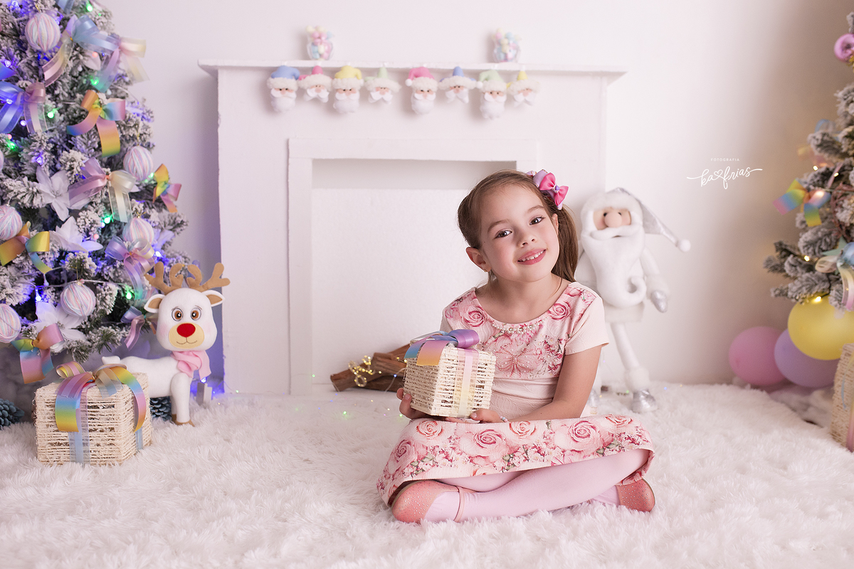 a menina segura o presente no ensaio de natal 2021 em caxias do sul-rs