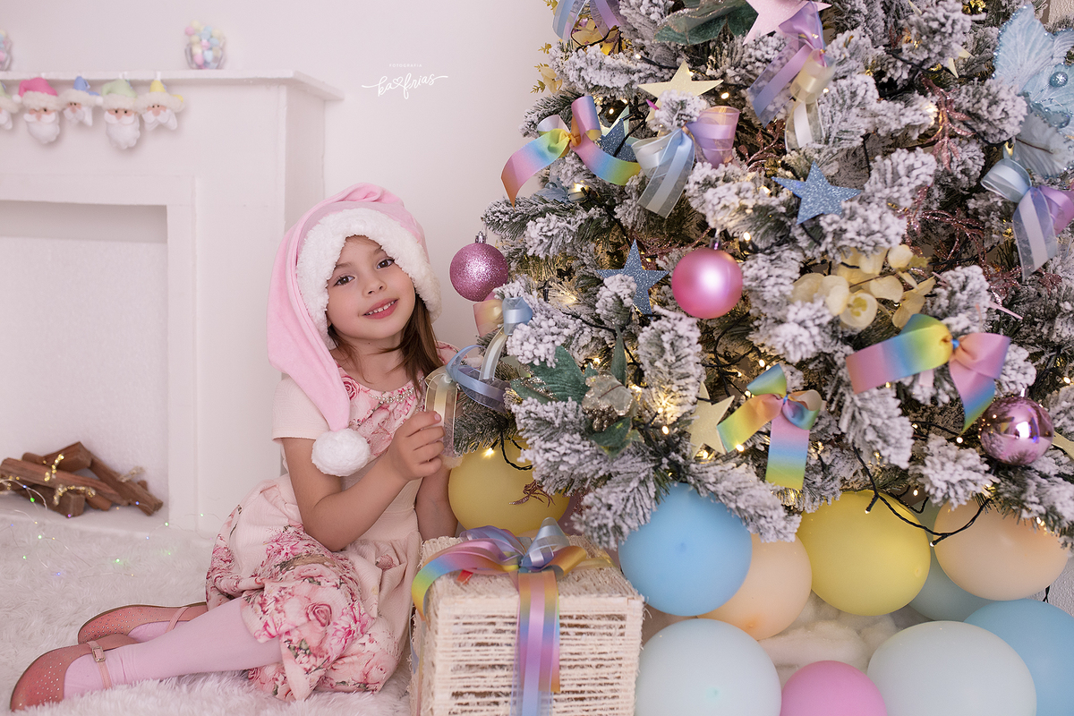a menina enfeita a arvore no ensaio de natal