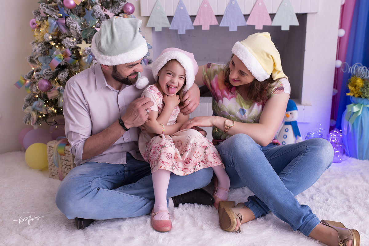 os pais brincam com a filha na sessão de natal 2021