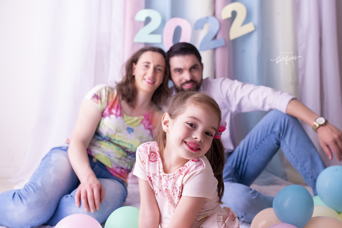 a menina fica a frente deixando os pais desfocados