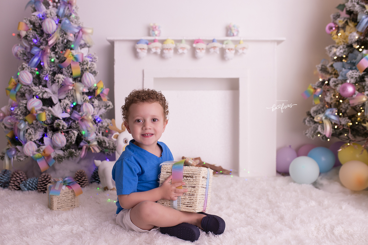 o menino segura o presente para as fotos de natal