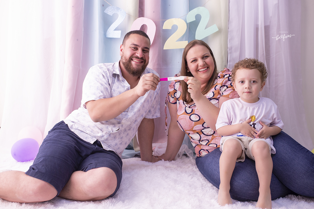 no ensaio de ano novo a familia mostra o exame de gravidez de mais um filho que esta por vir