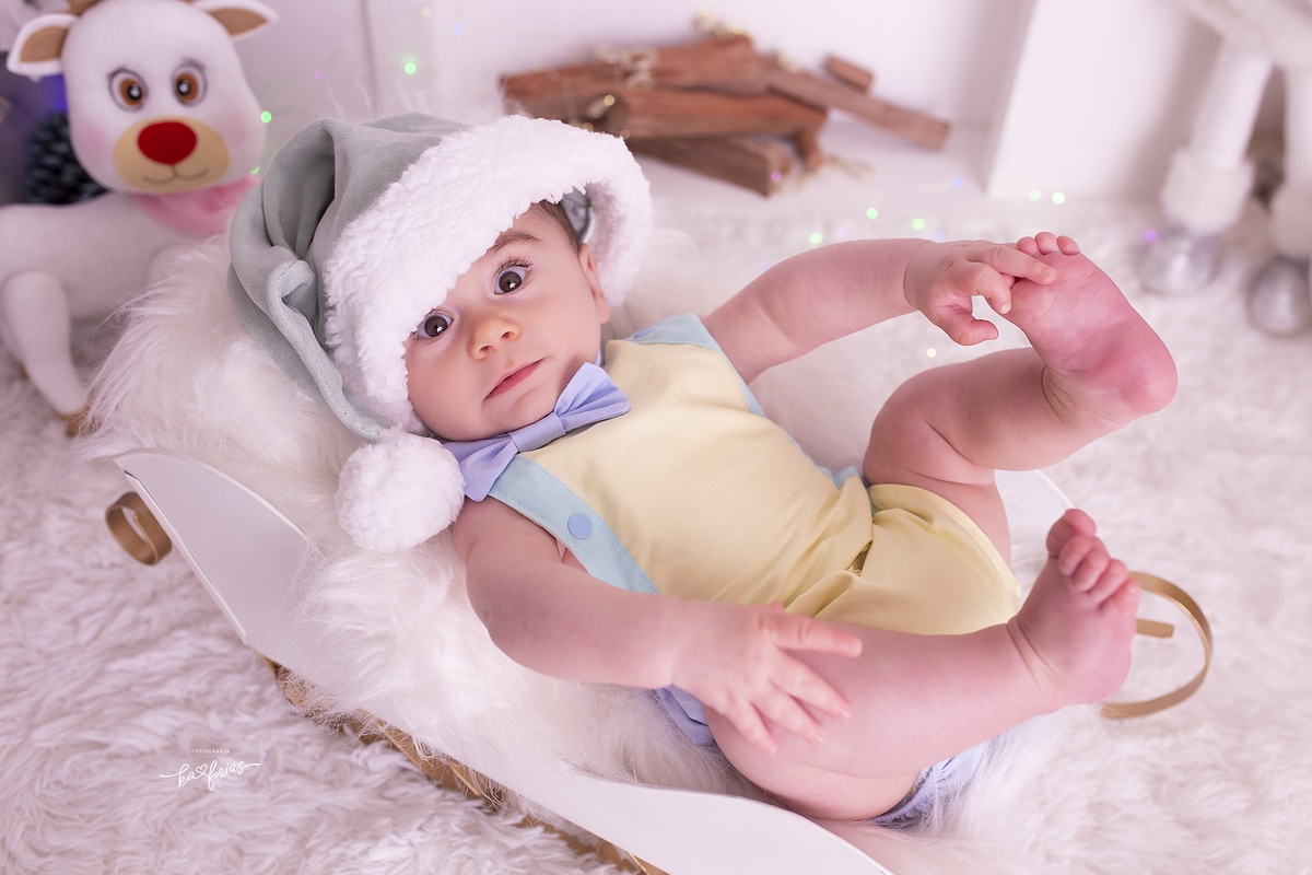no ensaio de natal o bebe segura o pe