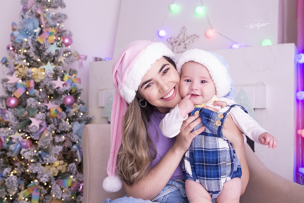 no ensaio de natal a mae abraça o bebe