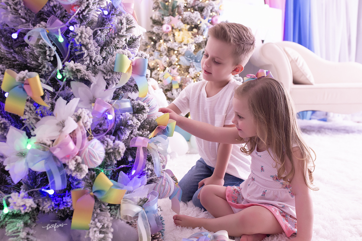 os irmaos enfeitam a arvore durante sessÃO DE FOTOS