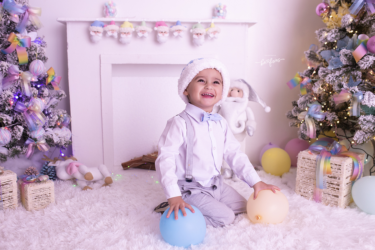 o menino sorri durante sessão de natal