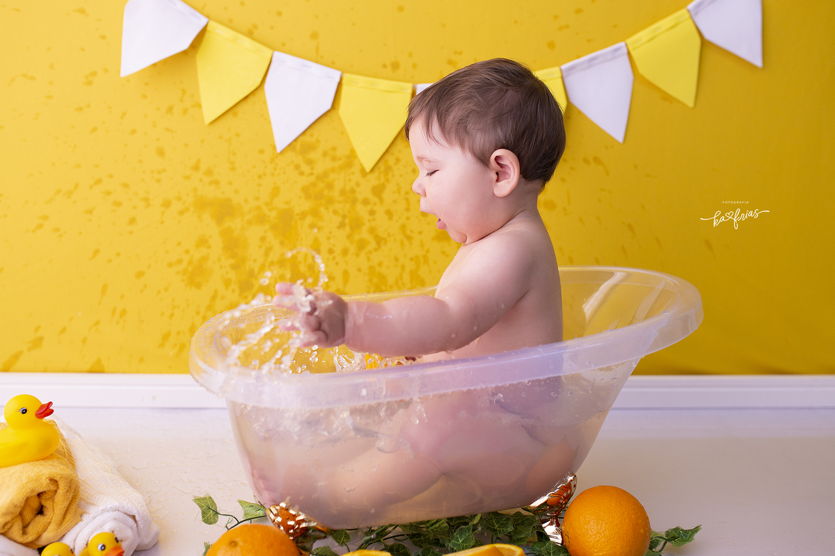 o bebe joga agua fora da banheira na sessão de fotos