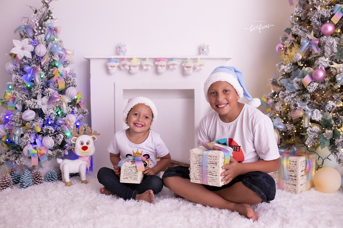 os irmaos seguram presentes no ensaio de natal 2021