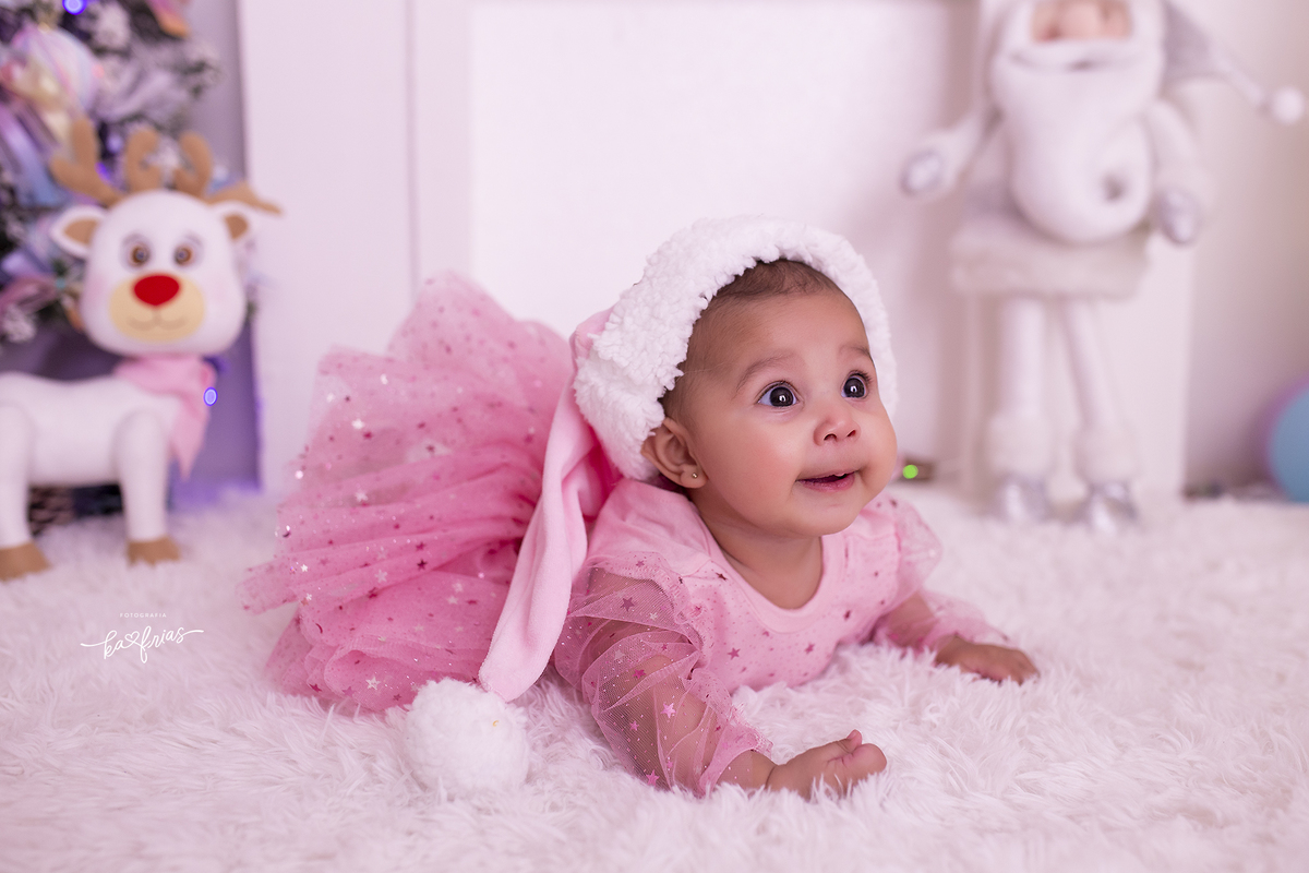 a menina olha para os pais e sorri durante ensaio de natal