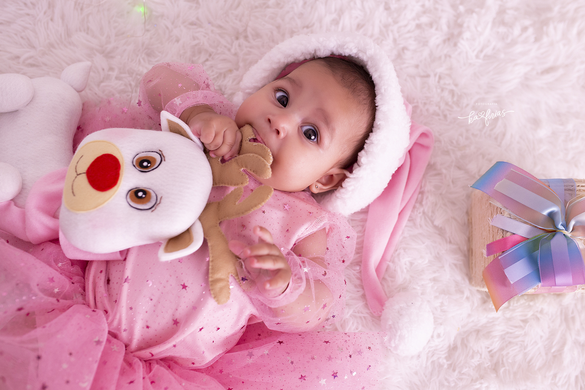 a menina brinca com a rena durante sessão de fotos