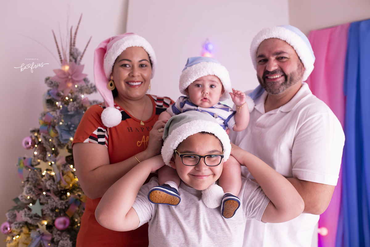 o irmao mais velho poe o bebe nos ombros no ensaio de natal