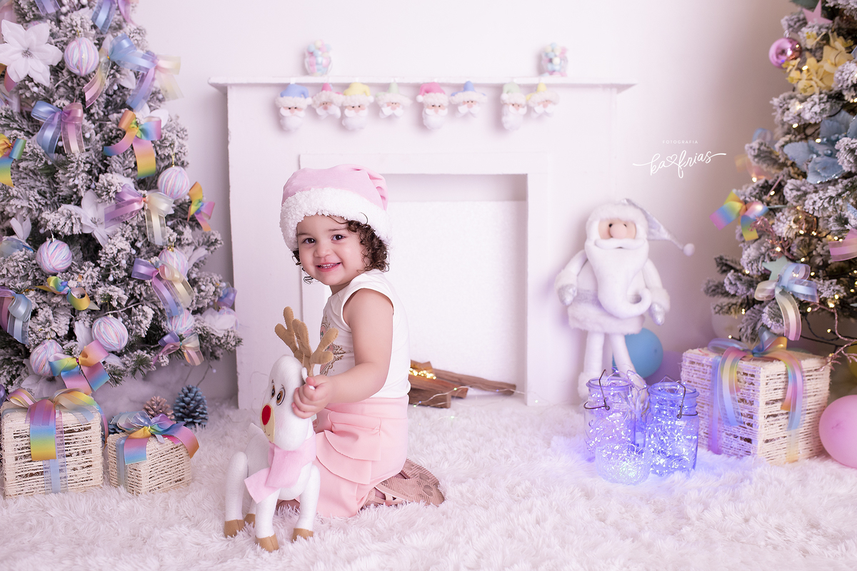 a menina brinca com a rena no cenario de natal