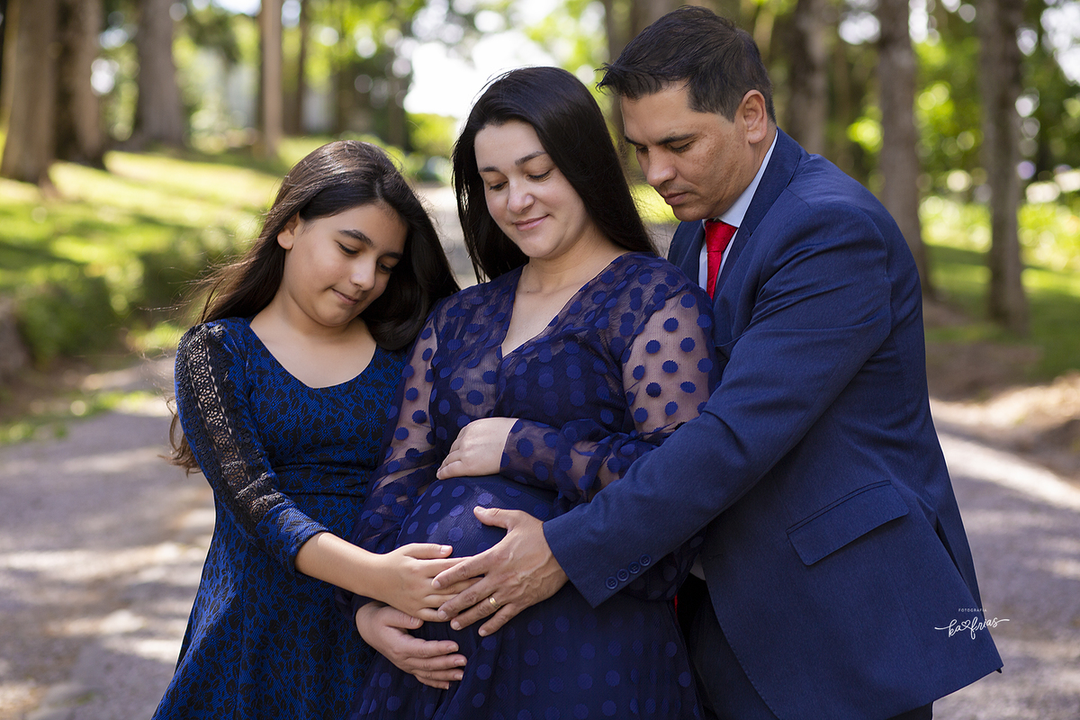 todos olham para a barriga na sessão externa de gestante