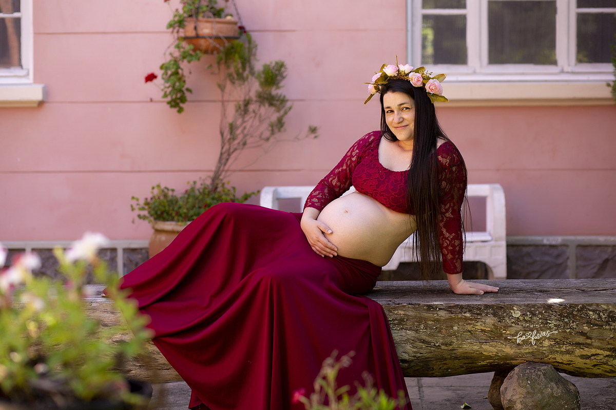 a gestante esta sentada para as fotos do seu book