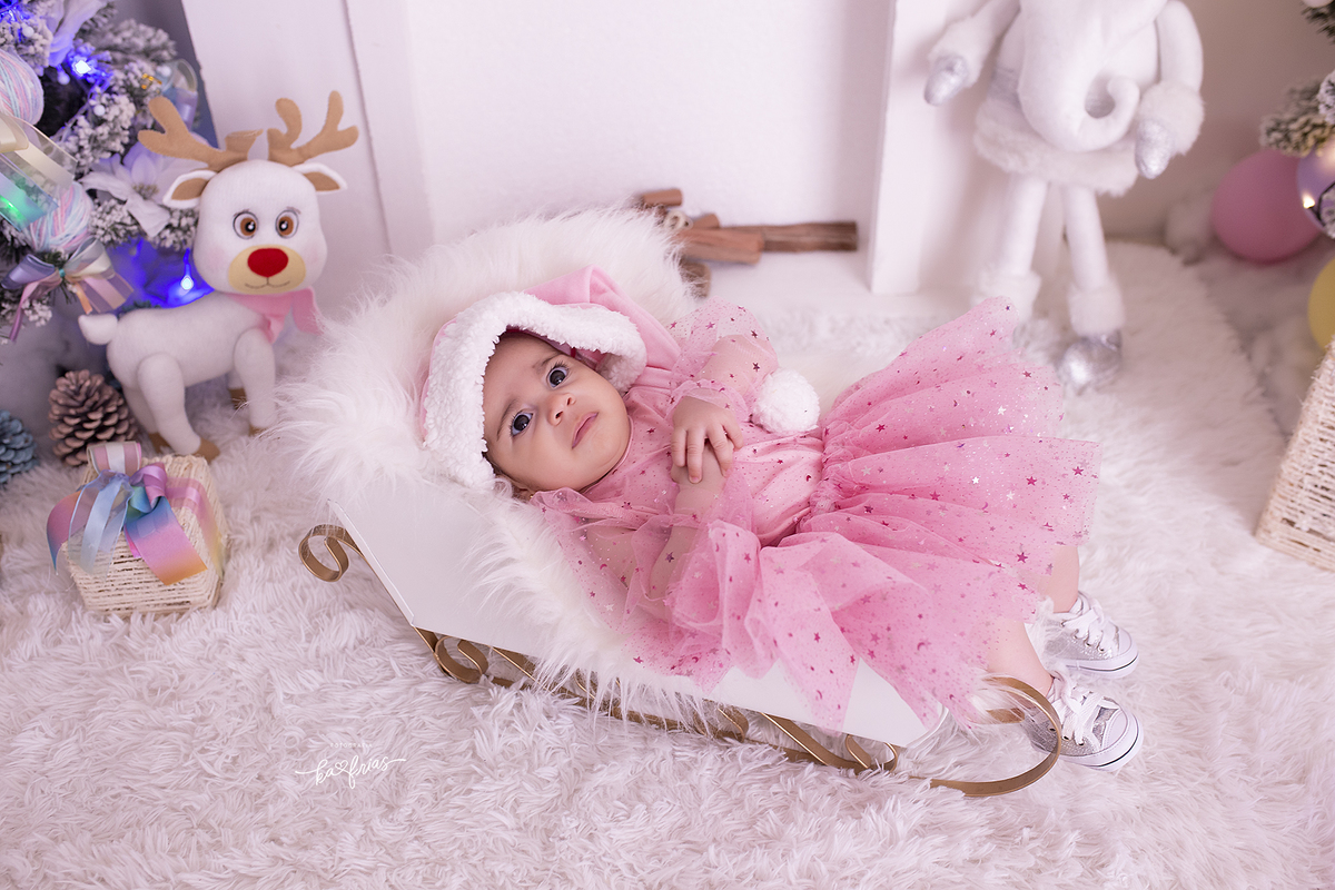 a menina esta deitada no treno de papai noel 