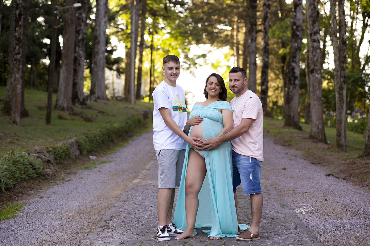 a mae posa com o esposo e filho no ensaio de gestante