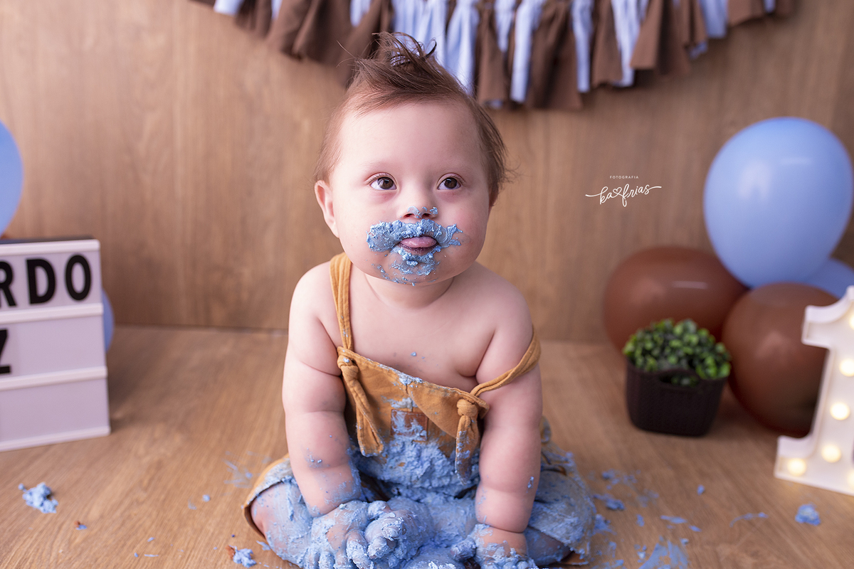 o menino mostra a lingua no ensaio com o bolo