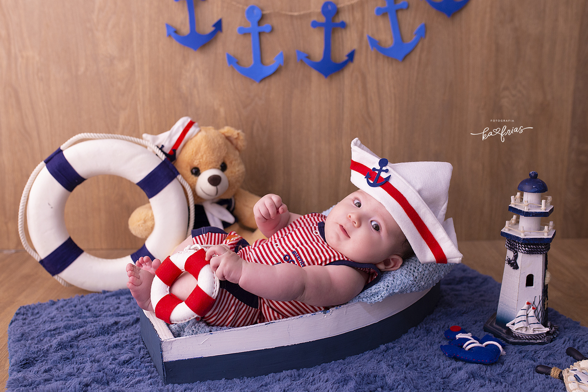 o menino esta vestido de marinheiro para suas fotos de 3 meses