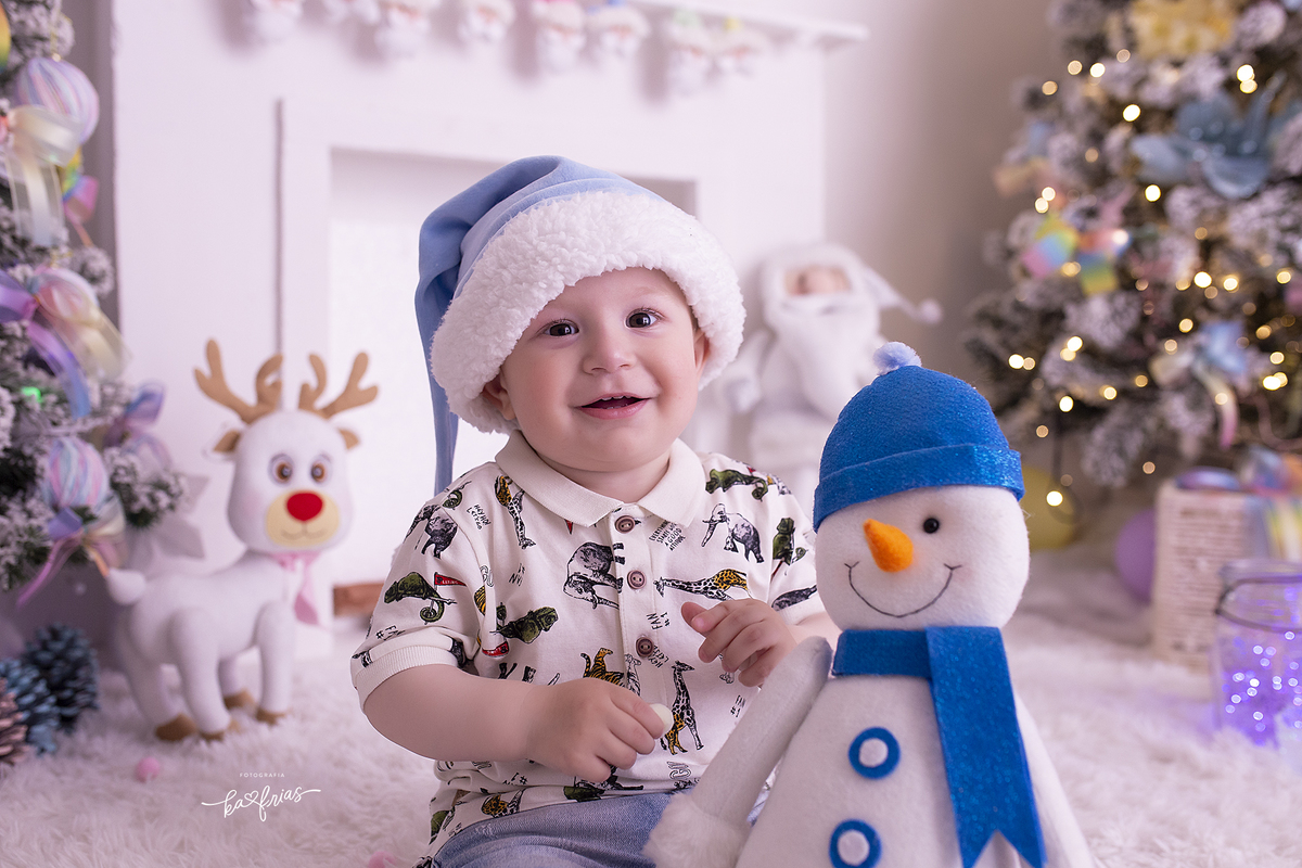 o menino segura o boneco de neve no ensaio de natal