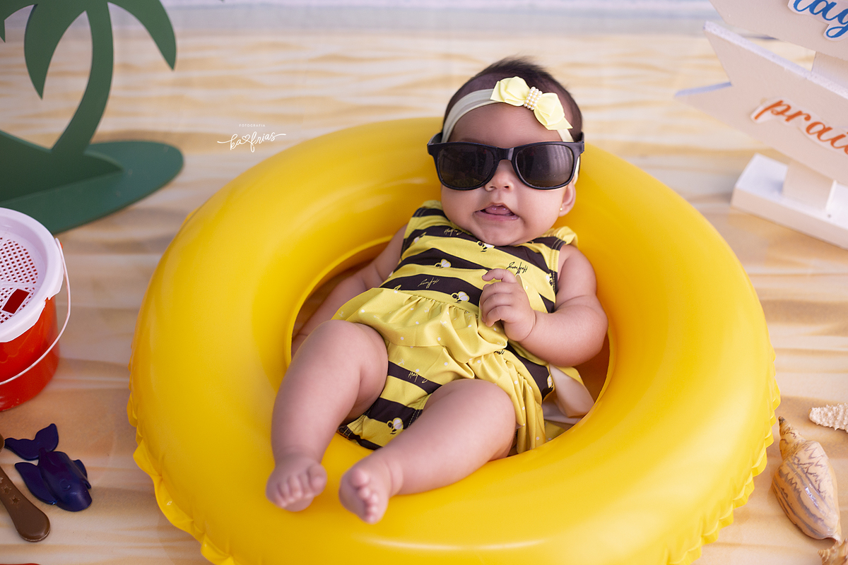 a bebe esta de oculos de sol par as fotos mensais
