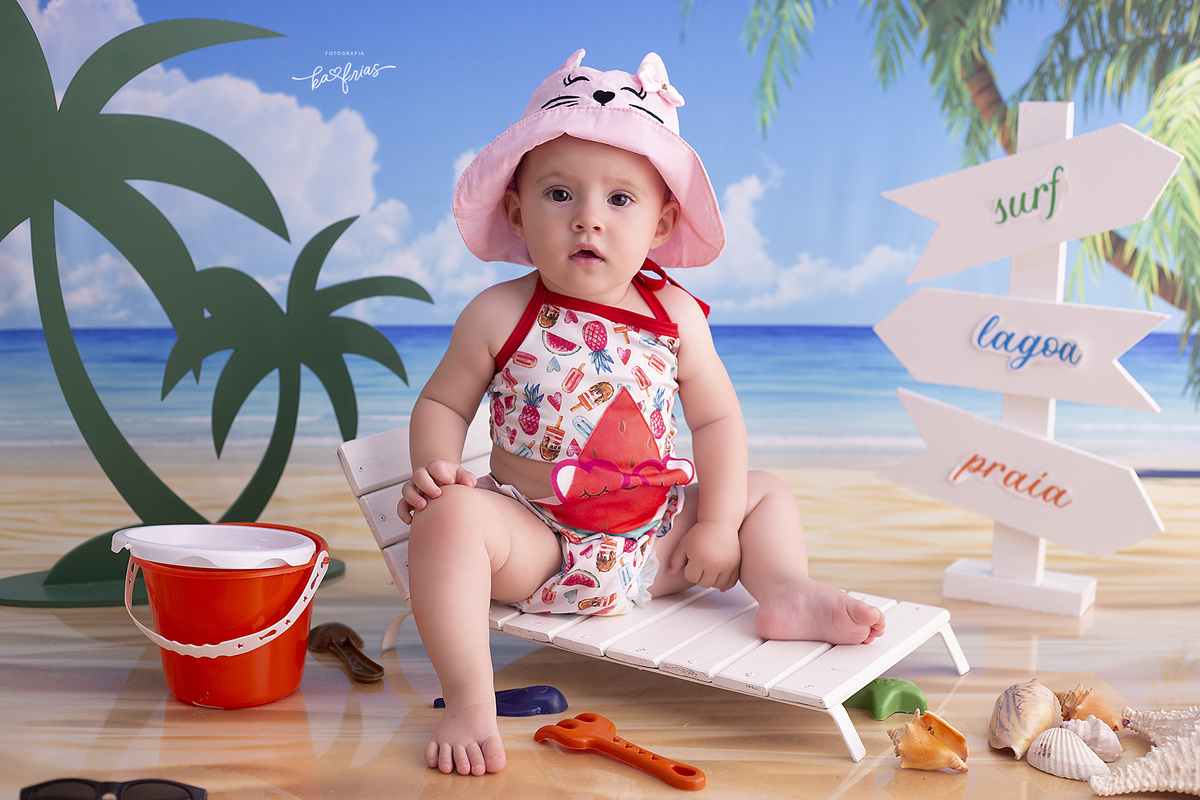 a menina esta no cenario de praia para as fotos mensais