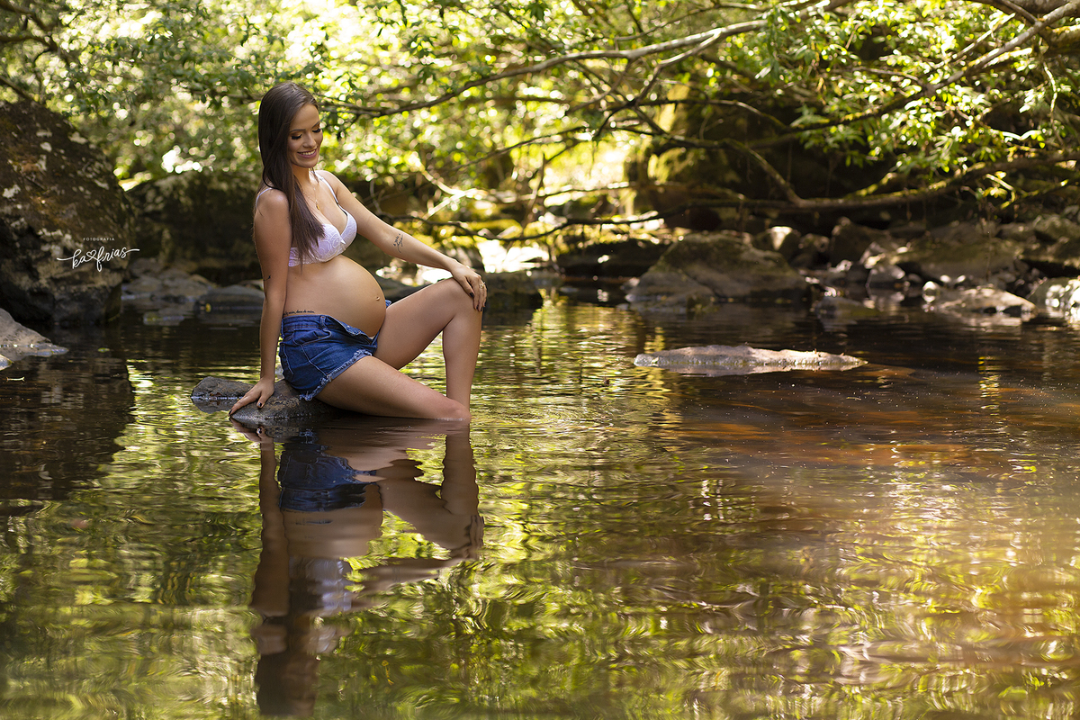 a gestante esta na agua do rio para a sessão de fotos