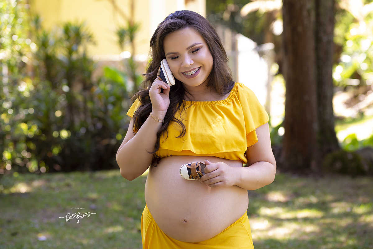 no book externo de gestante a modelo poe o sapatinho na barriga
