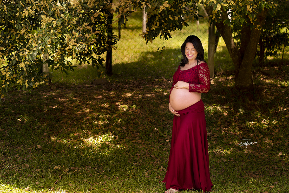 a gestante olha para a barriga no ensaio externo