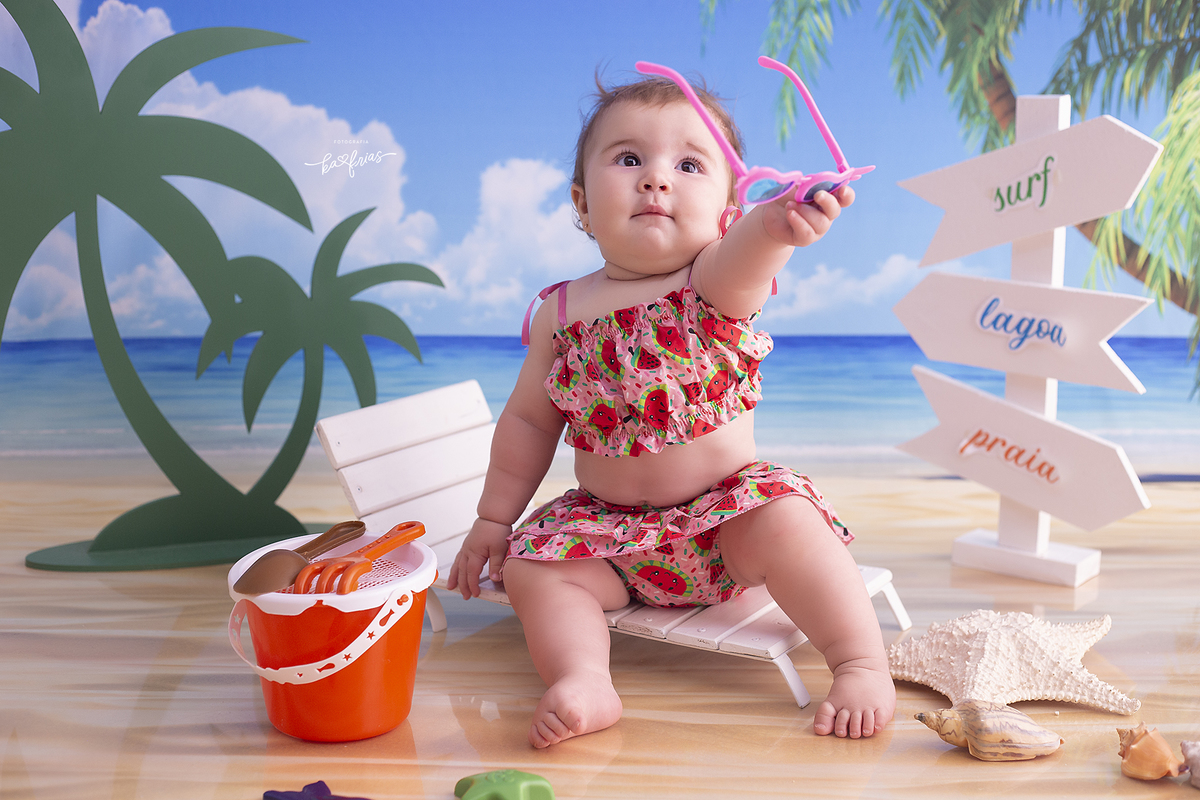 no acompanhamento mensal a bebe mostra os oculos de sol