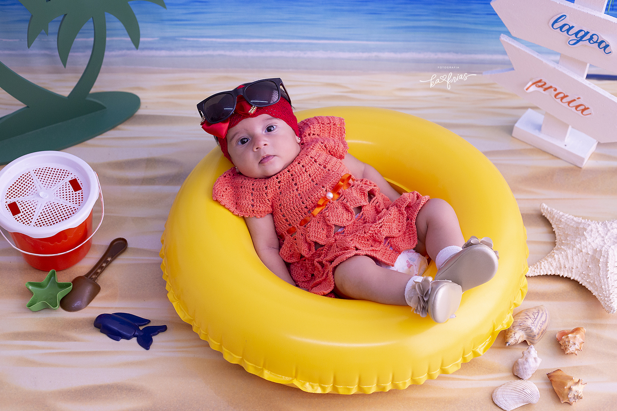a bebe esta de oculos de sol para as fotos de praia