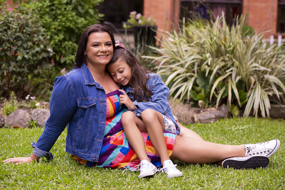 a menina pede o colo da mae no ensaio de familia