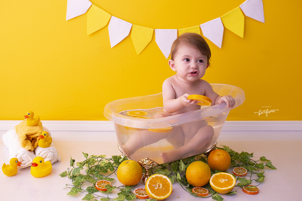 a bebe faz careta com as laranjas durante sessão infantil