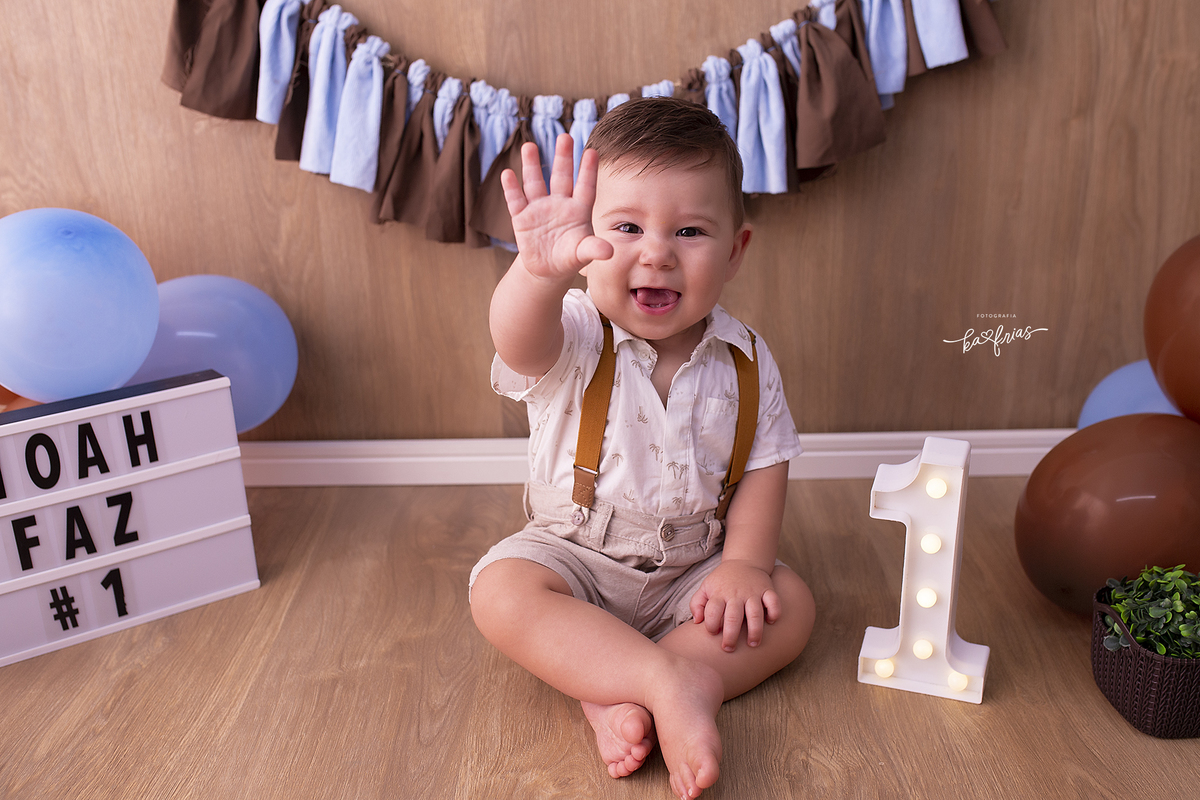 o bebe manda tchau nas fotos de seu ensaio de um ano