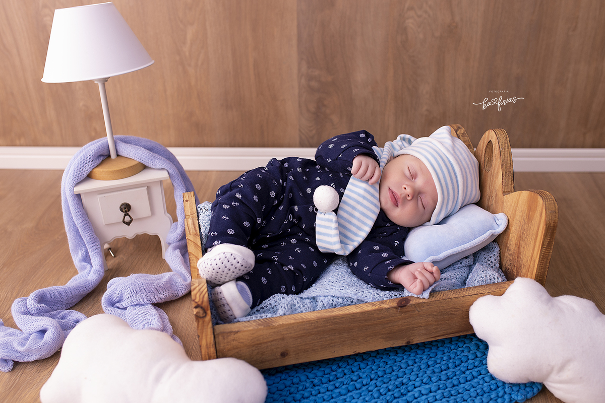 o menino esta deitado na caminha para as fotos de um mês