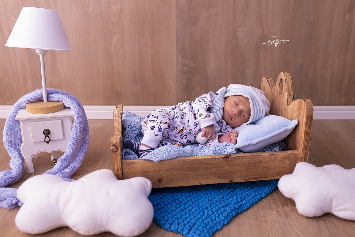 o bebe esta deitado na caminha para a sessão de fotos