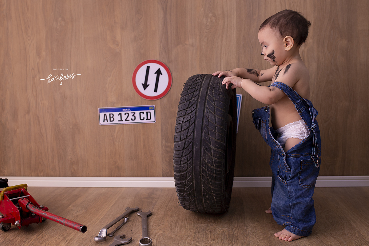 o menino mexe no pneu para a sessão de fotos