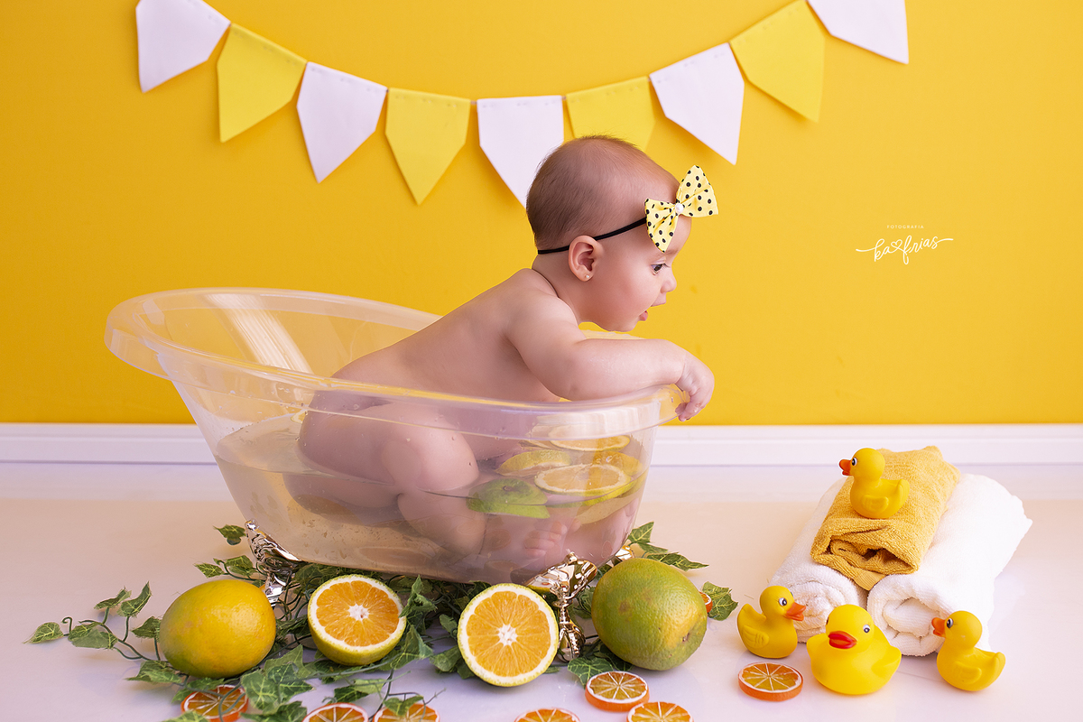 a menina esta olhando para  o patinho no ensaio de banheira