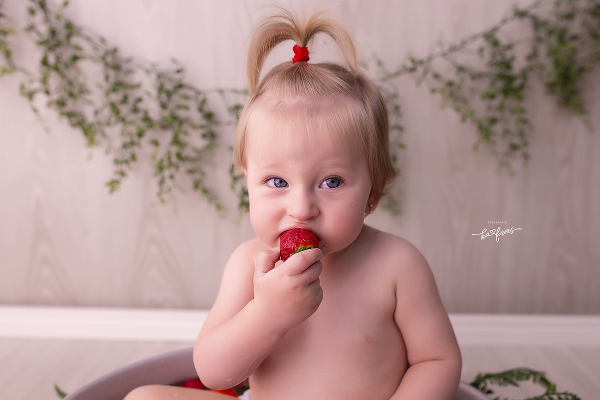 a menina morde a fruta durante sessão de fotos