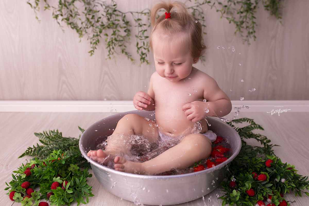 a bebe joga agua fora da bacia no ensaio com agua
