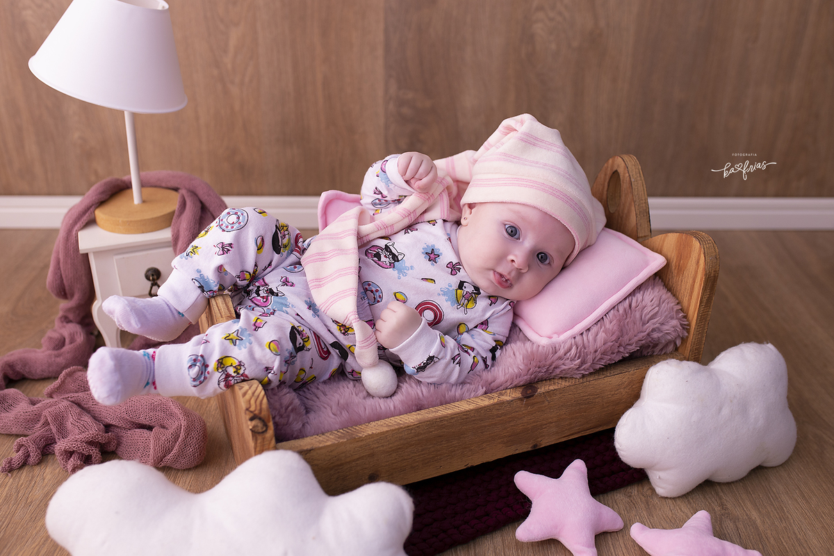 a menina esta deitada na cama para as fotos de acompanhamento mensal