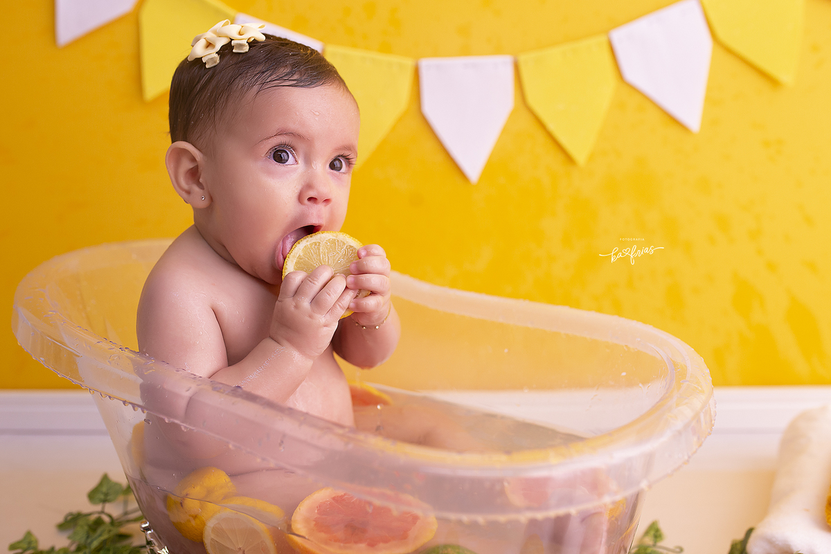 a bebe come a laranja na sessão de fotos
