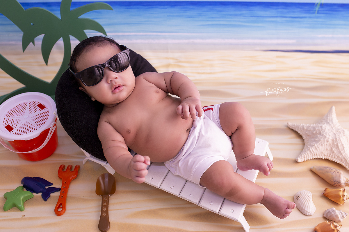 no ensaio infantil, o bebe esta na praia