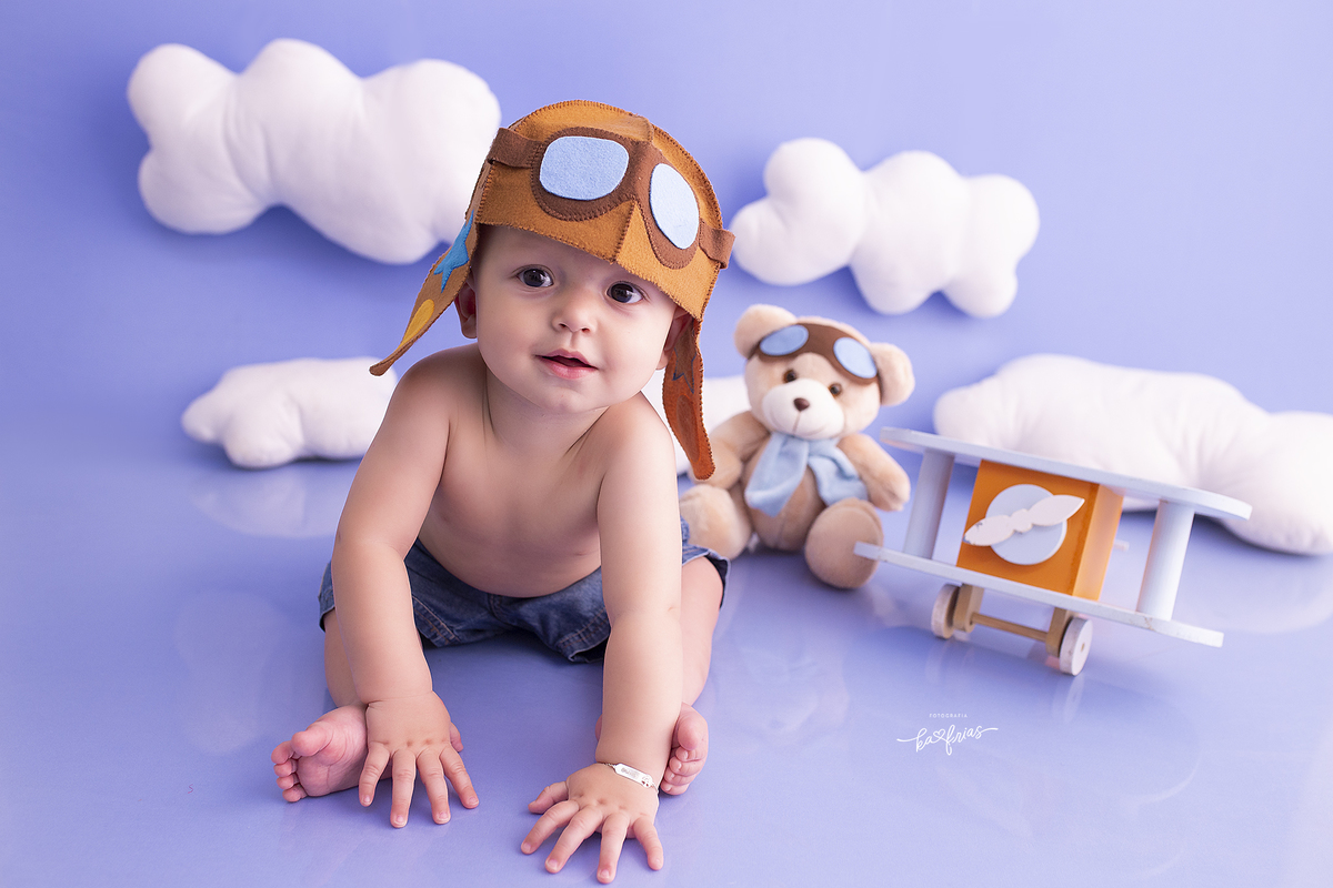 o menino esta vestido de aviador para as fotos mensais