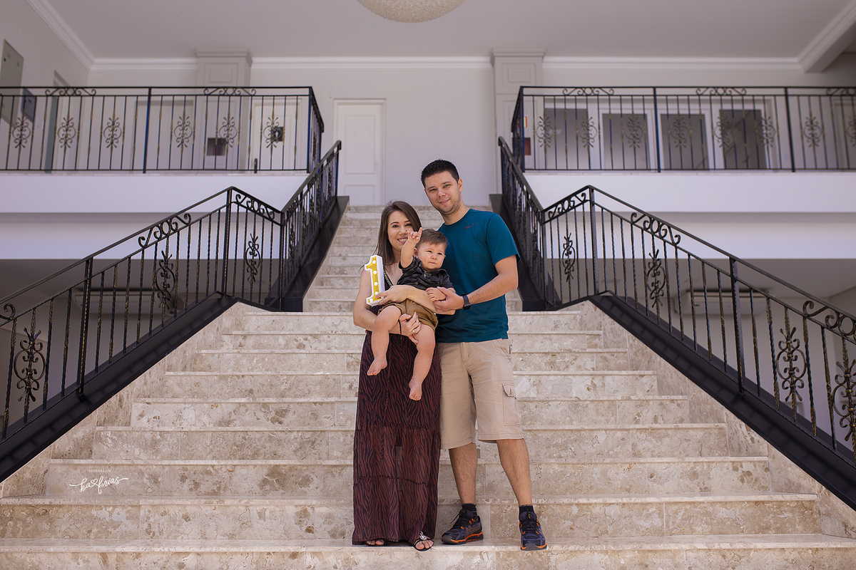 os pais posam com o bebe na escada