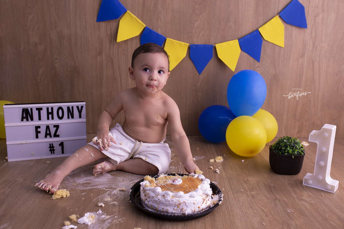 o bebe se sujou com o bolo no ensaio infantil