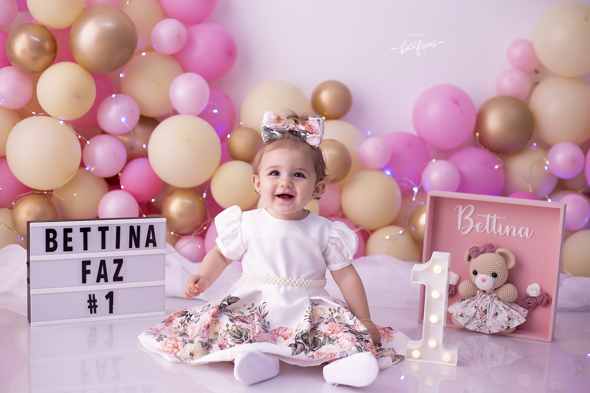 a menina posa nas fotos de um aninho