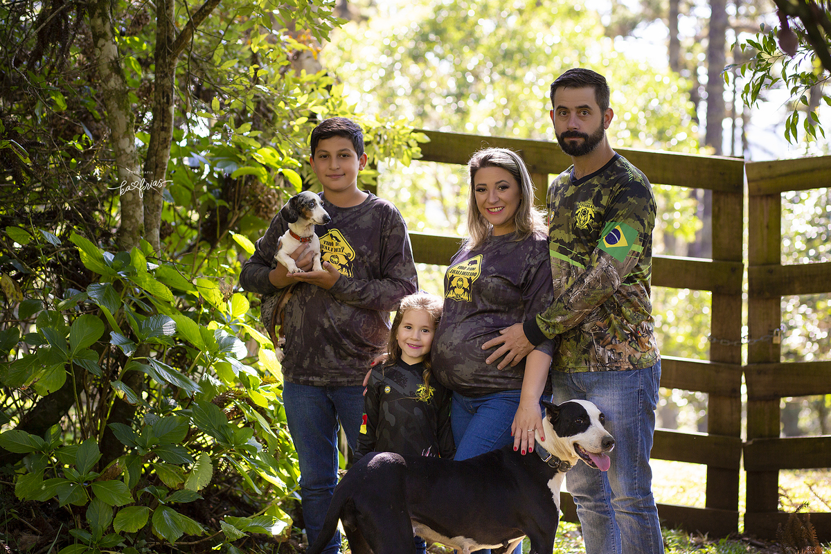 a familia posa no ensaio de gestante externo
