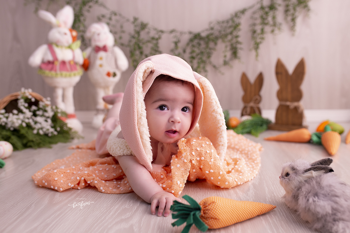 a bebe tenta pegar a cenoura no ensaio infantil